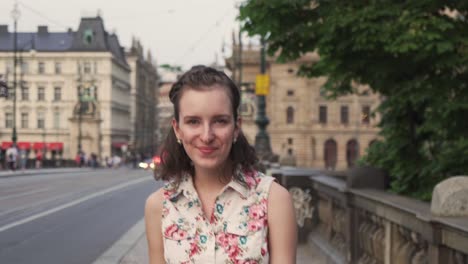 girl walking in street of prague city, turning and looking into camera, face or head closeup view