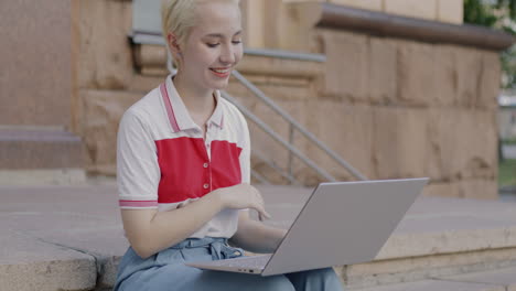 mujer joven trabajando en una computadora portátil al aire libre
