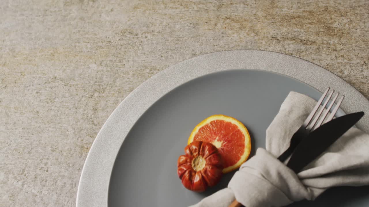 Vídeo de plato con decoración naranja y otoñal sobre un tapete beige