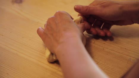 women’s hands making a figure out of dough