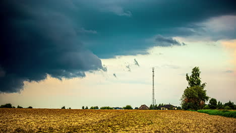 Nubes-Tormentosas-Sobre-Campos-De-Cultivo-Y-Una-Torre-Celular-En-El-Campo---Lapso-De-Tiempo