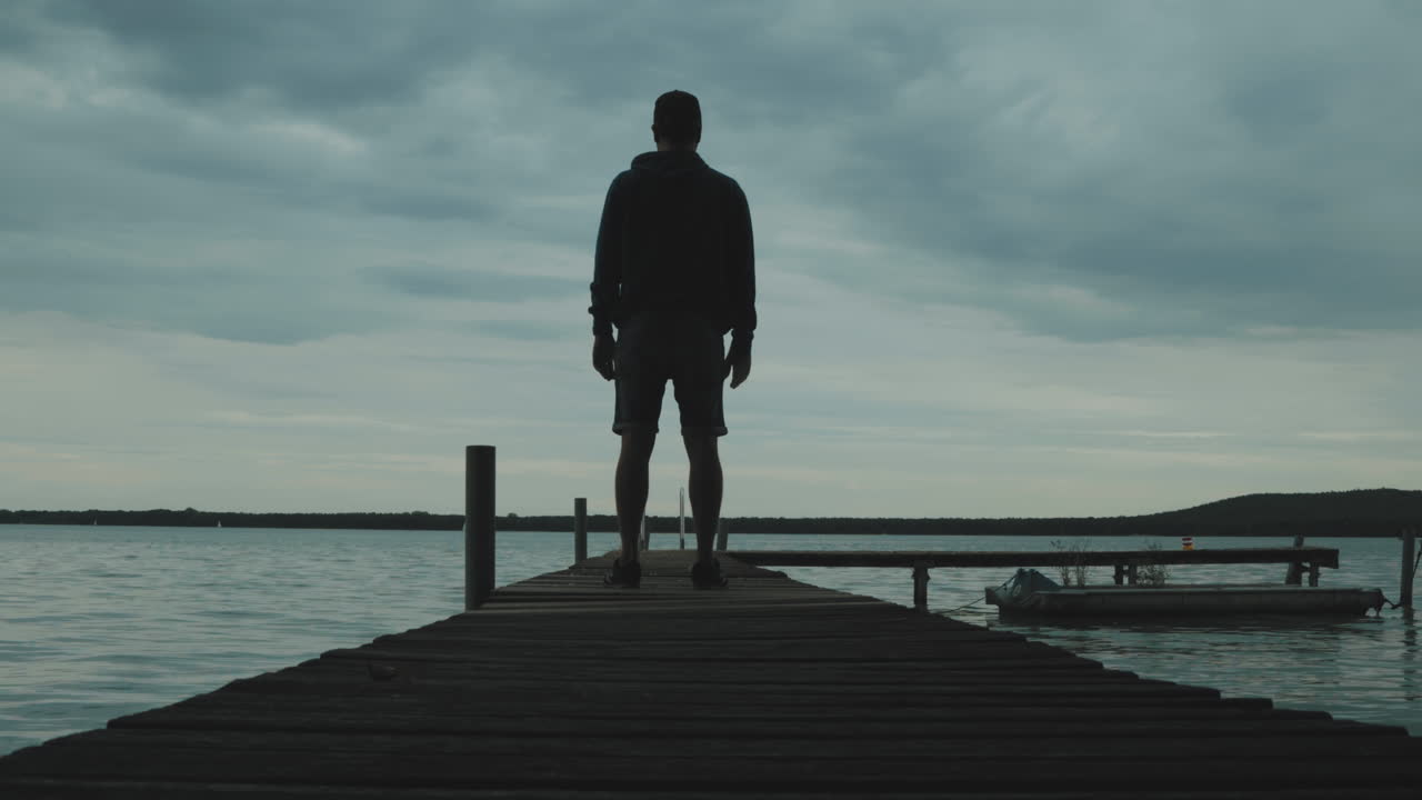 Timlapse of a Man standing on al little per at a Müggelsee lake