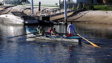 three people rowing a boat on a lake