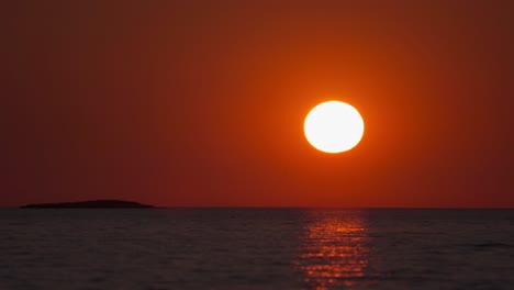 太陽在夏天在克羅埃西亞海邊落下,在溫柔的海浪上