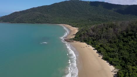 Cow-Bay-in-Daintree-Rainforest-backward-aerial-of-beach-and-mountain,-Queensland,-Australia