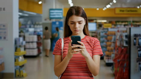 woman using smartphone in a supermarket