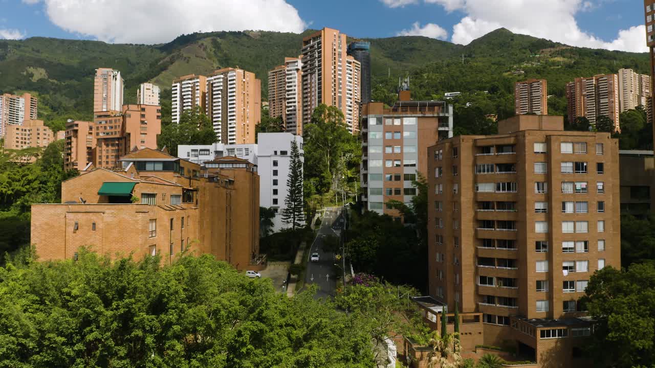 Tomada aérea de estabelecimento de bairro afluente sul-americano com montanhas ao fundo.