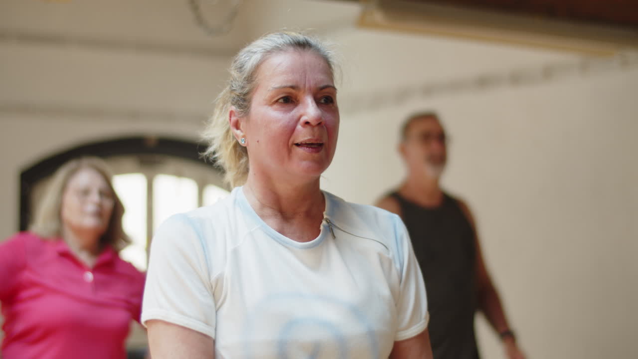 Halvtotalbilde av eldre kvinne som gjør fysiske øvelser i en ballsal