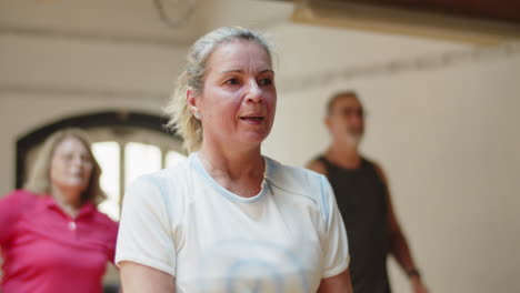 plano medio de una anciana haciendo ejercicios físicos en el salón de baile