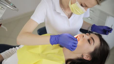 a pediatric dentist performs a dental examination on a young patient. the female stomatologist specializes in children’s dentistry, providing professional oral care in a modern clinic.