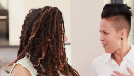 una pareja de lesbianas charlando juntos en el sofá.