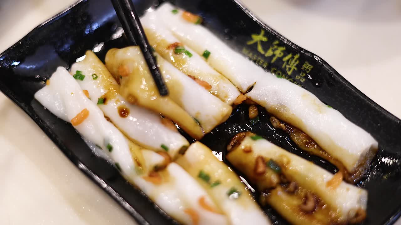 palillos para comer levantando rollos de fideos de arroz del plato