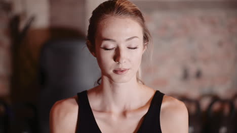 young female athlete practicing yoga during fitness training at health studio