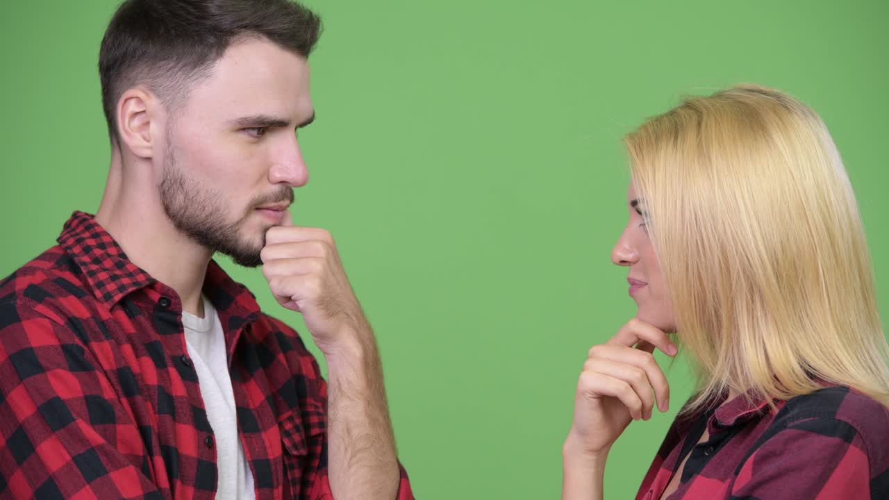 Mladý pár přemýšlí a dívá se na sebe.