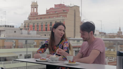 a couple enjoying coffee and desserts in a rooftop cafe in valencia