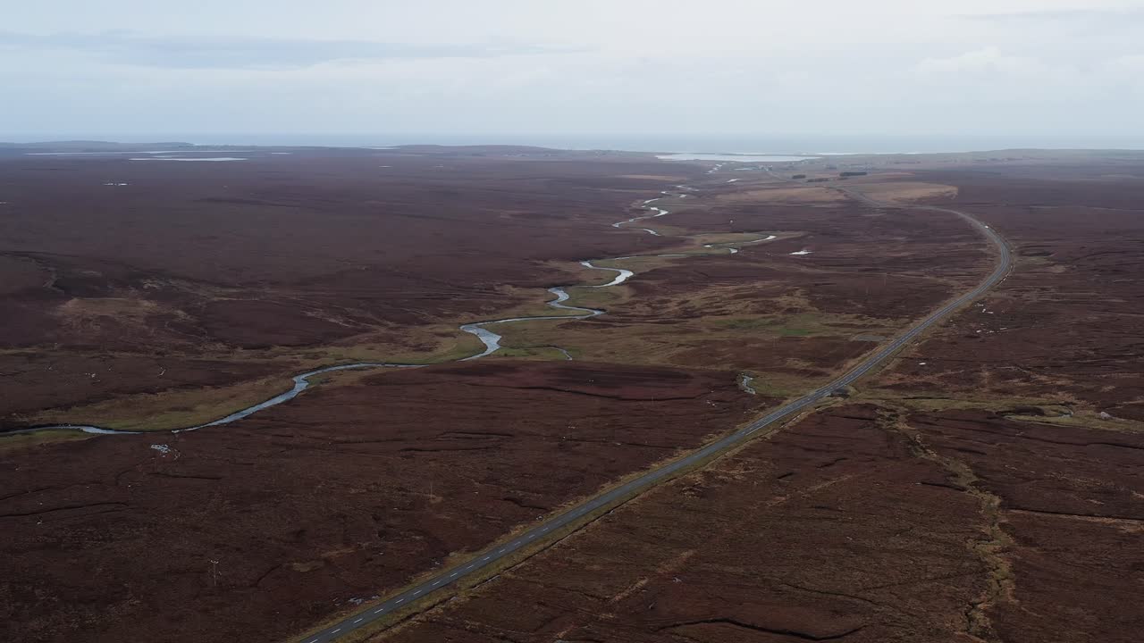 Ripresa aerea con drone e movimento panoramico del paesaggio della brughiera delle Ebridi, della strada e di un fiume