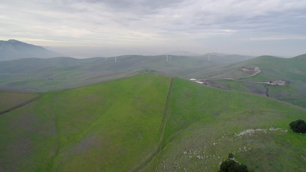 먼 바람 터빈의 역 돌리 연기 산 안개와 지나가는 브러쉬에  ⁇ 싸여