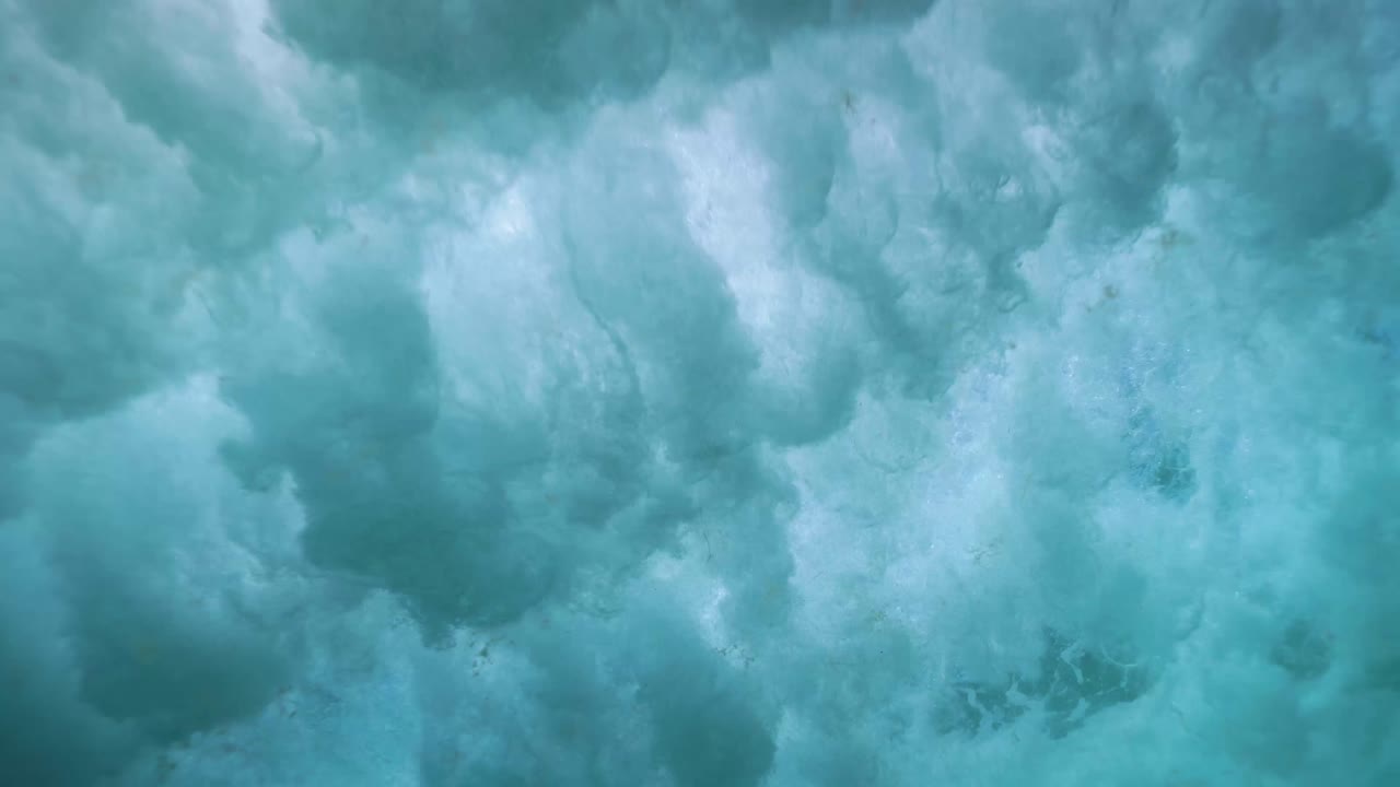 Vista subacquea di bolle create dalle onde sulla superficie al rallentatore