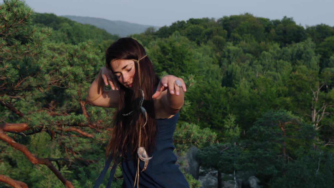 뒤에서, 여성은 드레스를 입고 바위의 배경에 바람에 날아다니는 드레스를 착용하는 것을 볼 수 있습니다.