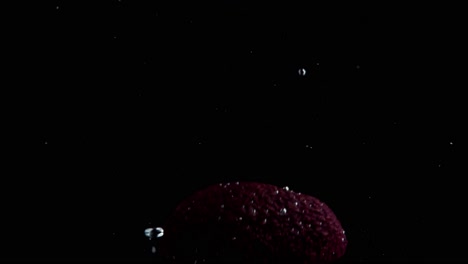 Avocado-Falling-into-Water-Super-Slowmotion,-Black-Background,-lots-of-Air-Bubbles,-4k240fps