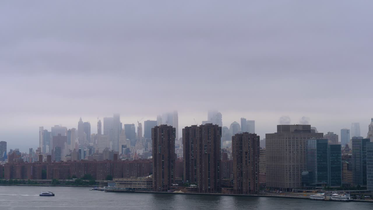 Establishing shot of Downtown Manhattan on a rainy, cloudy day with Stuyvesant Town-Peter Cooper Village and Waterside Plaza at the shore of East river in the foreground