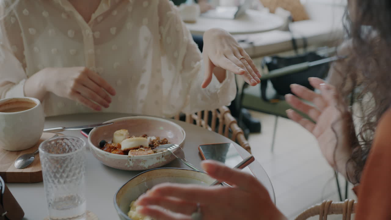 Women having breakfast and conversation in a cafe