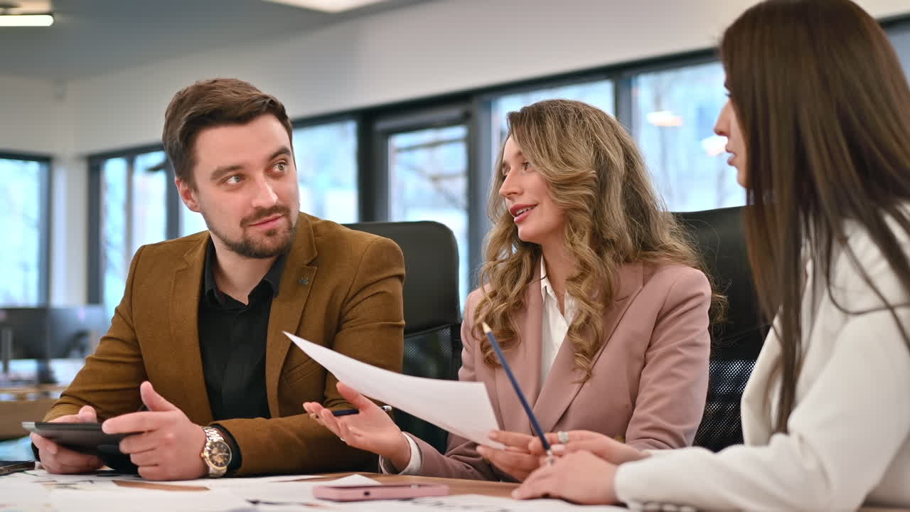 Business meeting in an office, workers discussing business affairs using papers. Slow motion