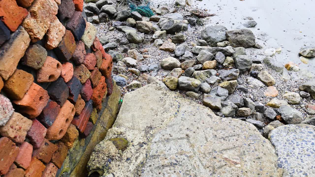 바위 와 벽돌 벽 에 부히는 파도