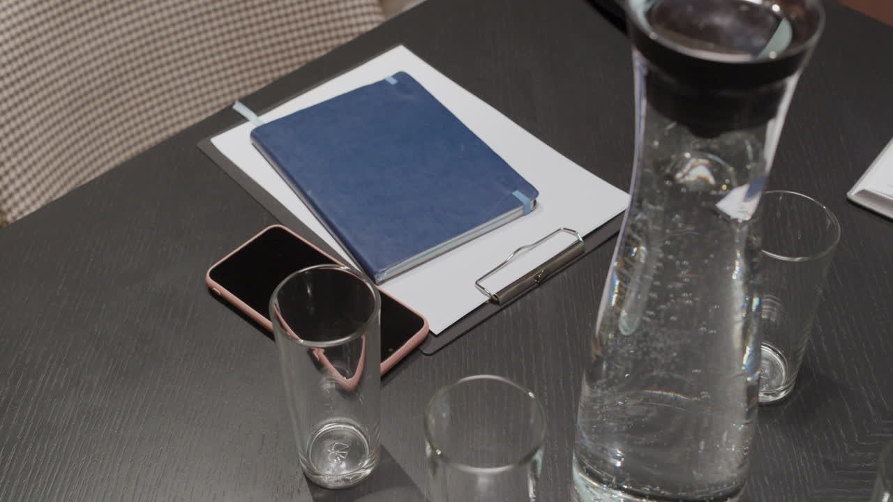 Conference Table Setup with Water and Office Supplies