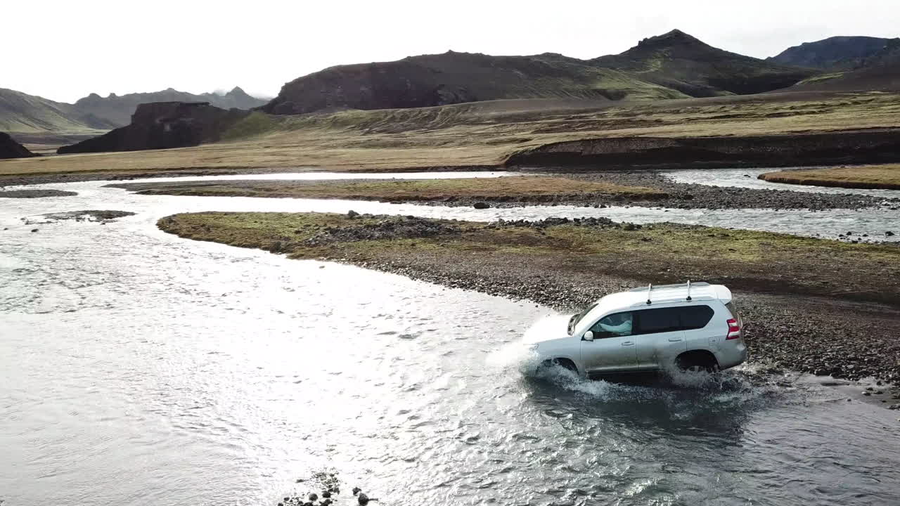 Four Wheel Vehicle Crossing Glacial River in Valley of Iceland Highlands, Aerial View