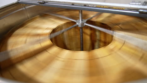 quick rotation of honey frames inside the centrifuge. wooden frames with honey combs spin to shake off liquid honey. top view.