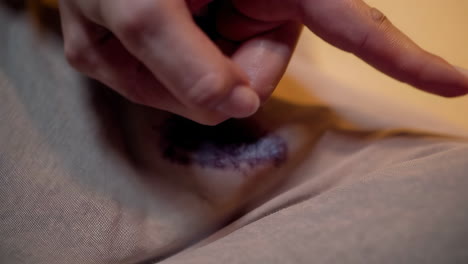 woman's hand touching a fabric with a stain