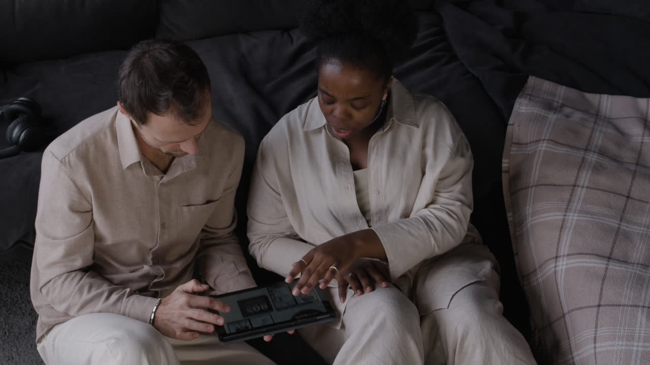Couple Relaxing at Home Using a Tablet