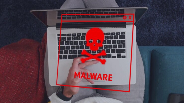 Man holding device activating red malware overlay on laptop, glitching while typing for security
