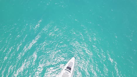 Beautiful-aerial-view-of-white-boat-yacht-in-blue-water-sun-glistening-blue-sky-white-clouds-vacation-tranquil-scenic