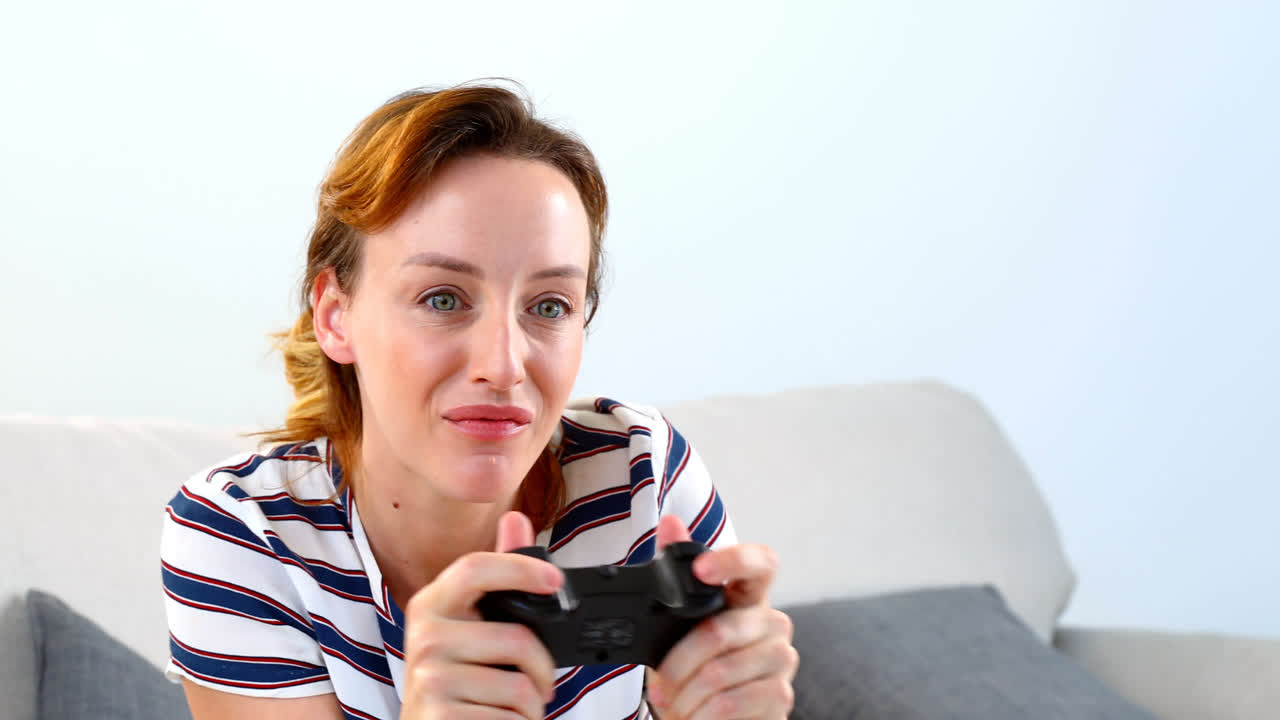 mujer jugando un juego de joystick en el sofá 4k