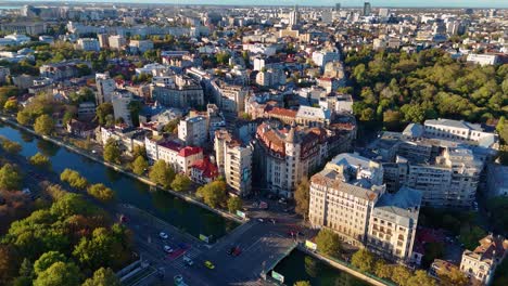 Una-Vista-Aérea-Del-Distrito-De-Izvor-En-Bucarest-Mientras-El-Río-Dambovita-Brilla-Al-Atardecer,-Rumania