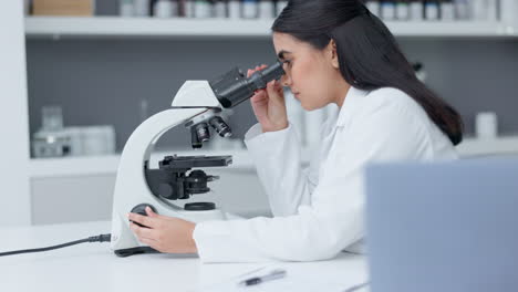 científico de laboratorio mirando en un microscopio para