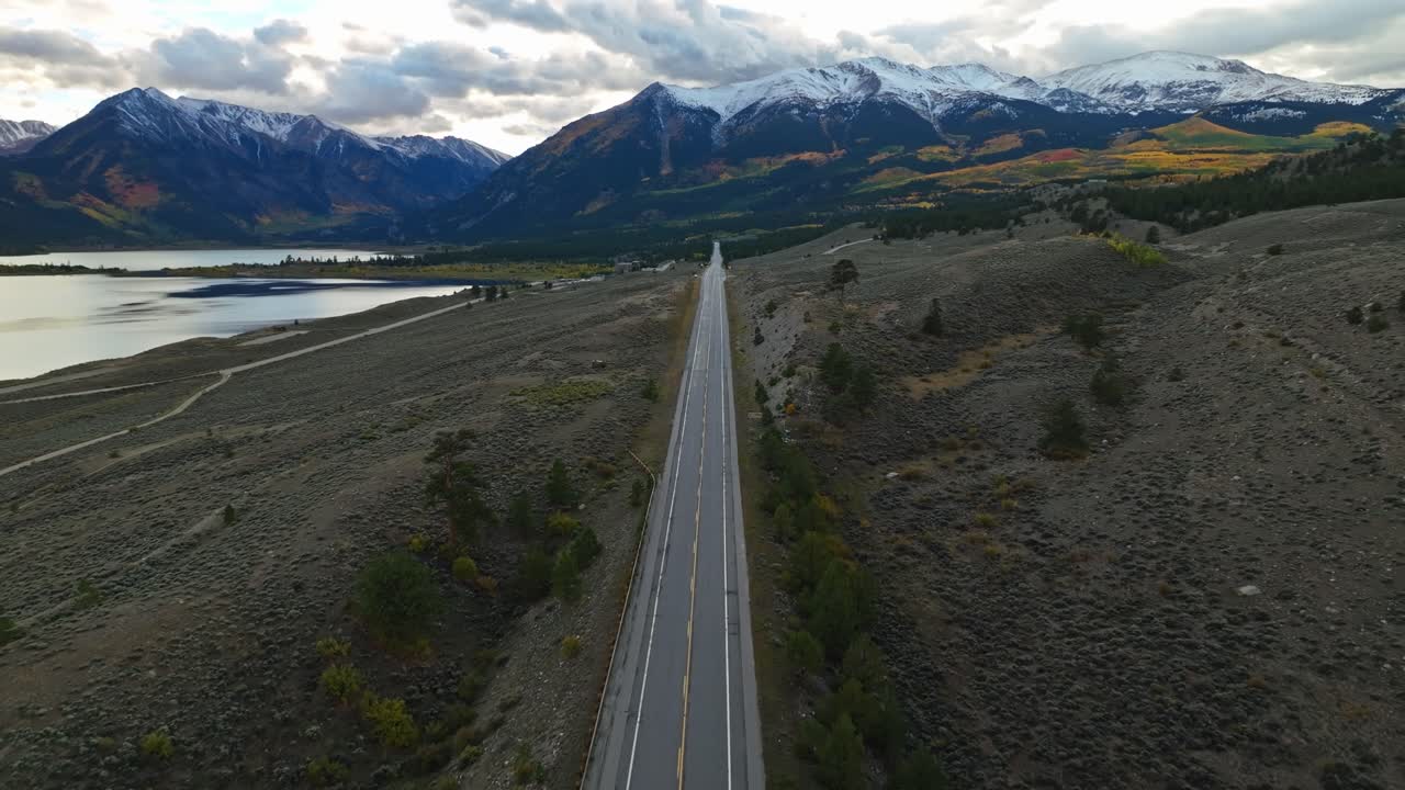 드론이 험난한 지형 위를 낮게 날아다니며 해가 지는 근처의 독립 패스의 바위 질감을 포착합니다.