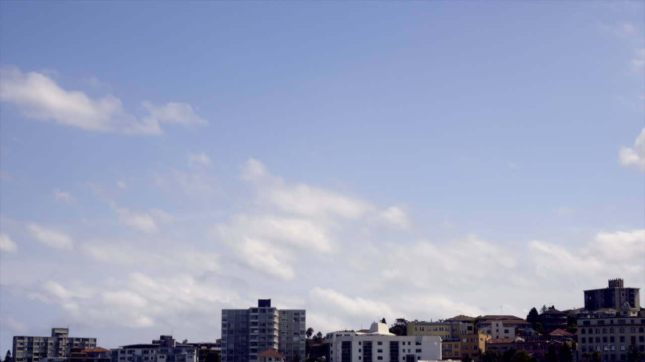 Time Lapse: White clouds moving across the sky above buildings in South Bondi, Sydney Australia
