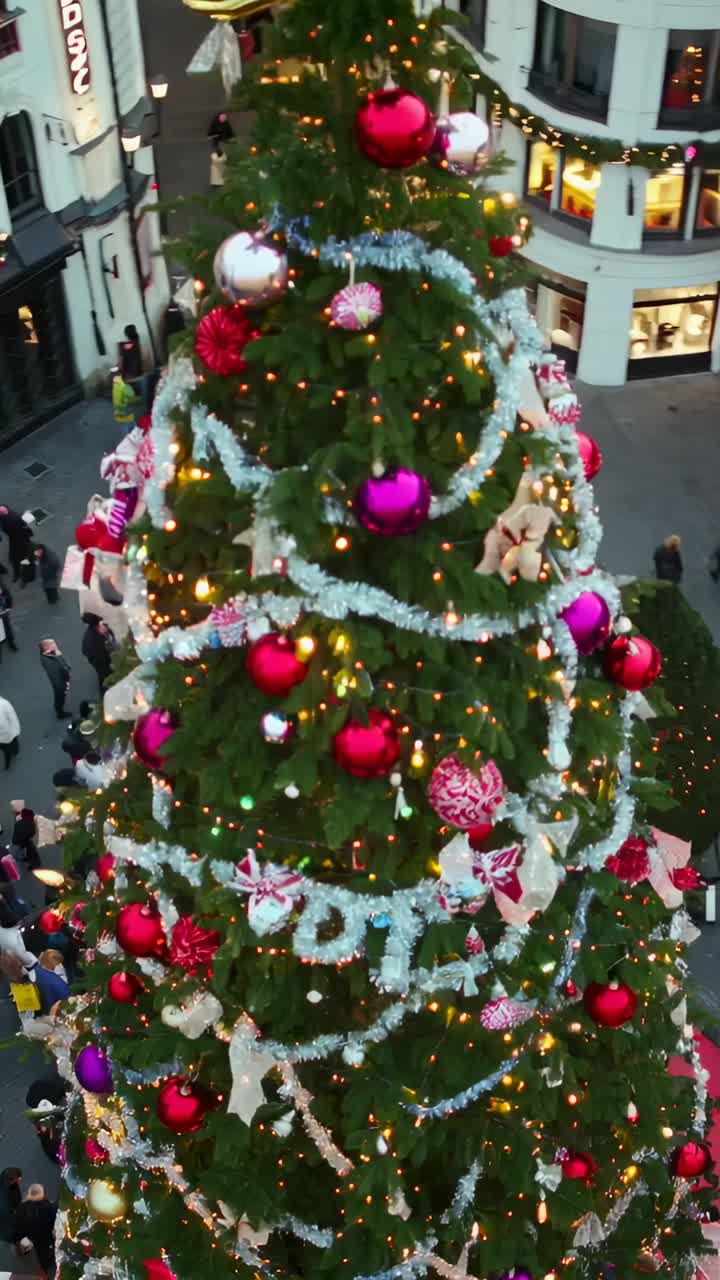 Vertical video: Camera circling decorated fir tree on busy street, revealing ornaments and shoppers