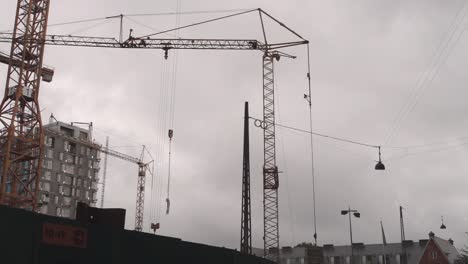 construction crane lifting construction object up on cloudy day