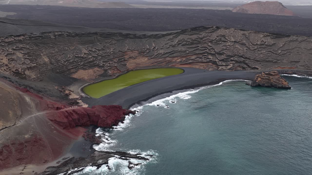 Aerial view circling El Golfo Charco de los Clicos colourful green lagoon on the Lanzarote coastline