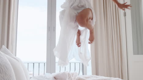 happy woman jumping on bed having fun laughing enjoying independent lifestyle celebrating freedom