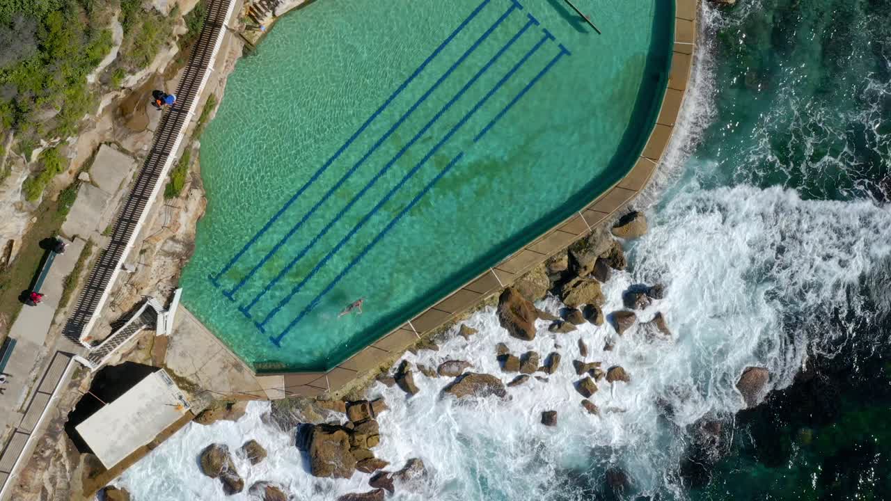 Les Bronte Baths - Une piscine populaire remplie d'eau de mer sur la plage de Bronte à Sydney, Nouvelle-Galles du Sud, Australie - vue aérienne plongeante.