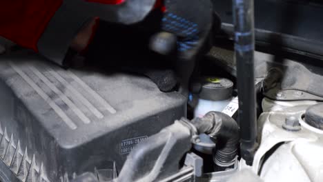 checking brake fluid in a car engine bay