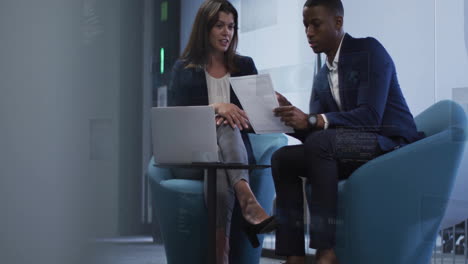 animation of financial data processing over diverse colleagues discussing work in office