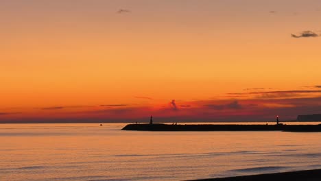 Timelapse-harbor-at-sunrise-with-boats-sailing-and-people-on-sea-wall