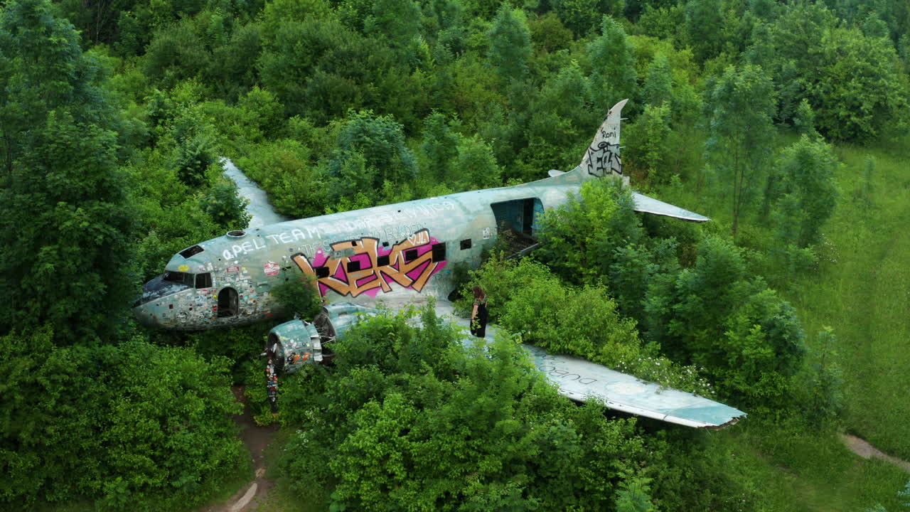 역사적인 공군 기지의 유적을 드러내기 위해 천천히 비행기를 향해 밀고 있는 드론 샷