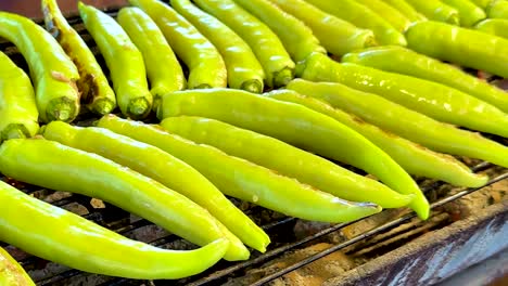 a close-up view of vibrant green peppers neatly arranged on a grill rack.